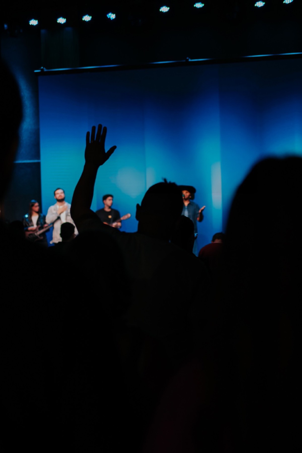 Igreja em adoração com a mão levantada diante da equipe de louvor