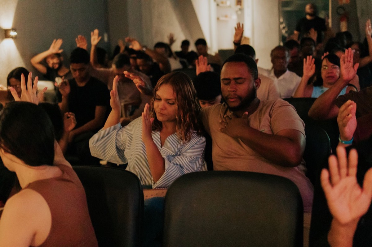 Casal orando junto com a igreja